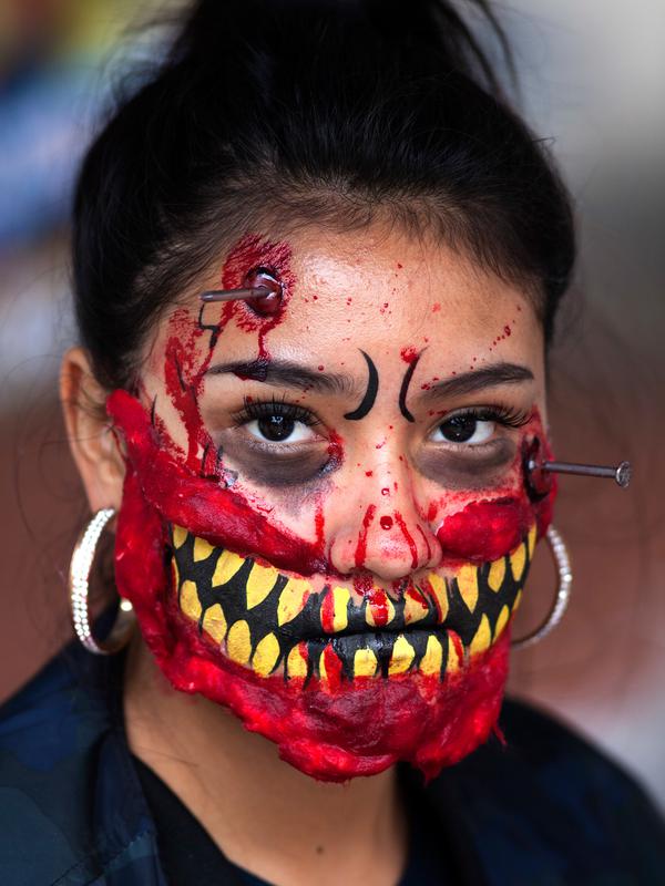 Seorang wanita berpartisipasi dalam Zombie Walk di Mexico City, Minggu (11/11). Dalam acara tahunan itu ratusan orang dengan penampilan yang seram serta mengenakan pakaian compang-camping berkumpul di pusat bersejarah ibu kota Meksiko. (AP/Claudio Cruz)