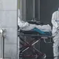 Staf medis memindahkan seorang pasien dari ambulans ke rumah sakit Jinyintan, tempat pasien-pasien terinfeksi virus corona dirawat di Wuhan, provinsi Hubei, China pada Senin 20 Januari 2020. (Source: AP)