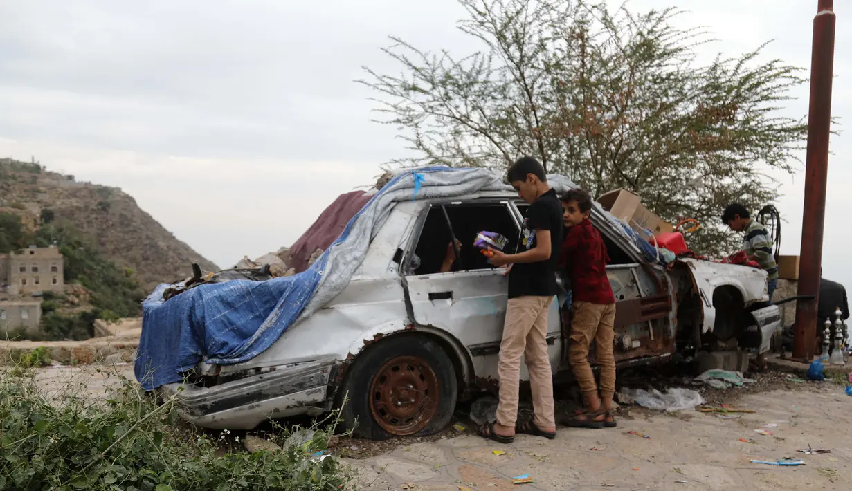 Anak-anak membeli permen di sebuah toko darurat di kawasan Jabal Sabr, Yaman pada 28 September 2019. Majd al-Din al-Shamiri (16) mengubah mobil keluarganya yang rusak parah, akibat perang yang melanda, menjadi toko darurat untuk mencari nafkah di tengah keadaan sulit. (Ahmad AL-BASHA/AFP)
