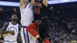 Pemain Chicago Bulls, Lauri Markkanen (kanan) melakukan tembakan melewati adangan pemain  Warriors, Zaza Pachulia pada laga NBA basketball game di Oracle Arena, Oakland, (24/11/2017). Warriors menang 143-94. (AP/Jeff Chiu)
