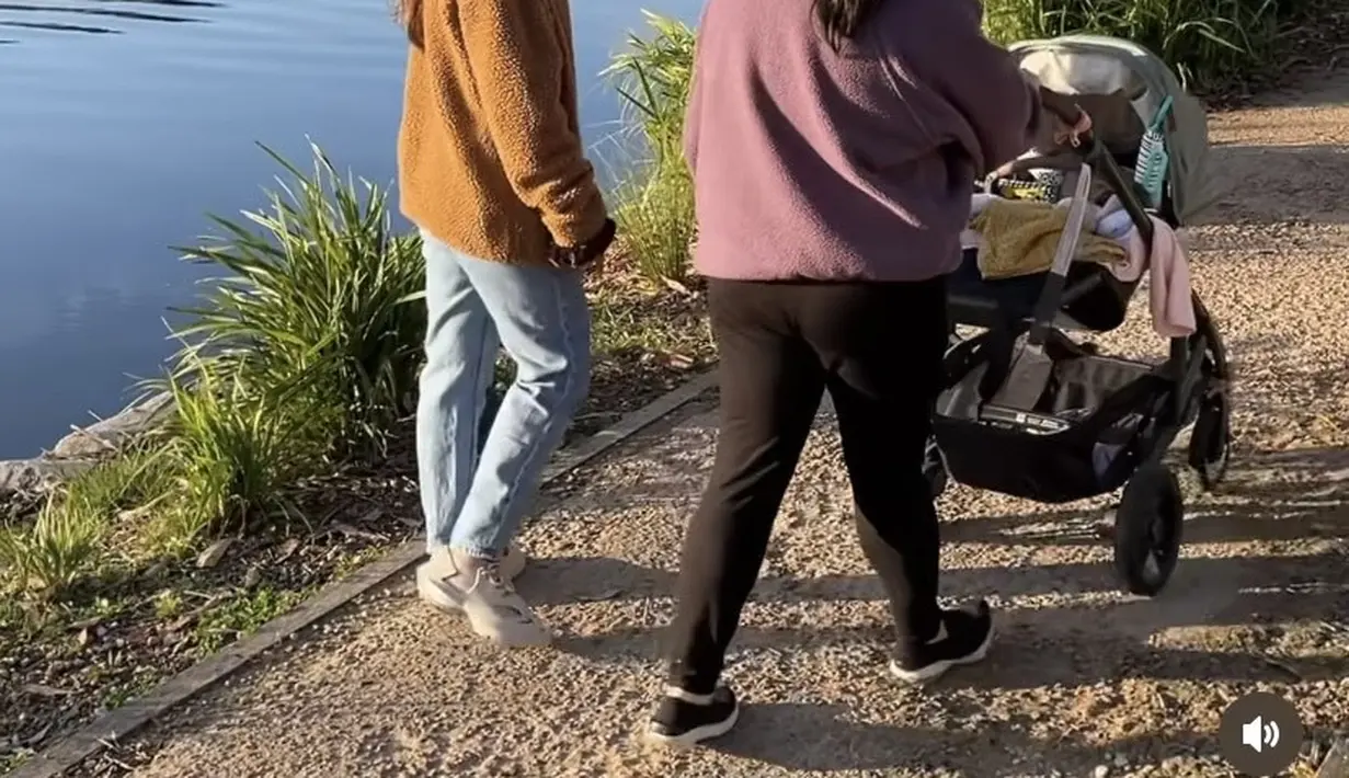 Berjalan di pinggir danau bersama kakak dan keponakannya, Sherina mengenakan jaket coklat berbulu dipadukan celana denimnya. [Instagram/@baskaramahendra]