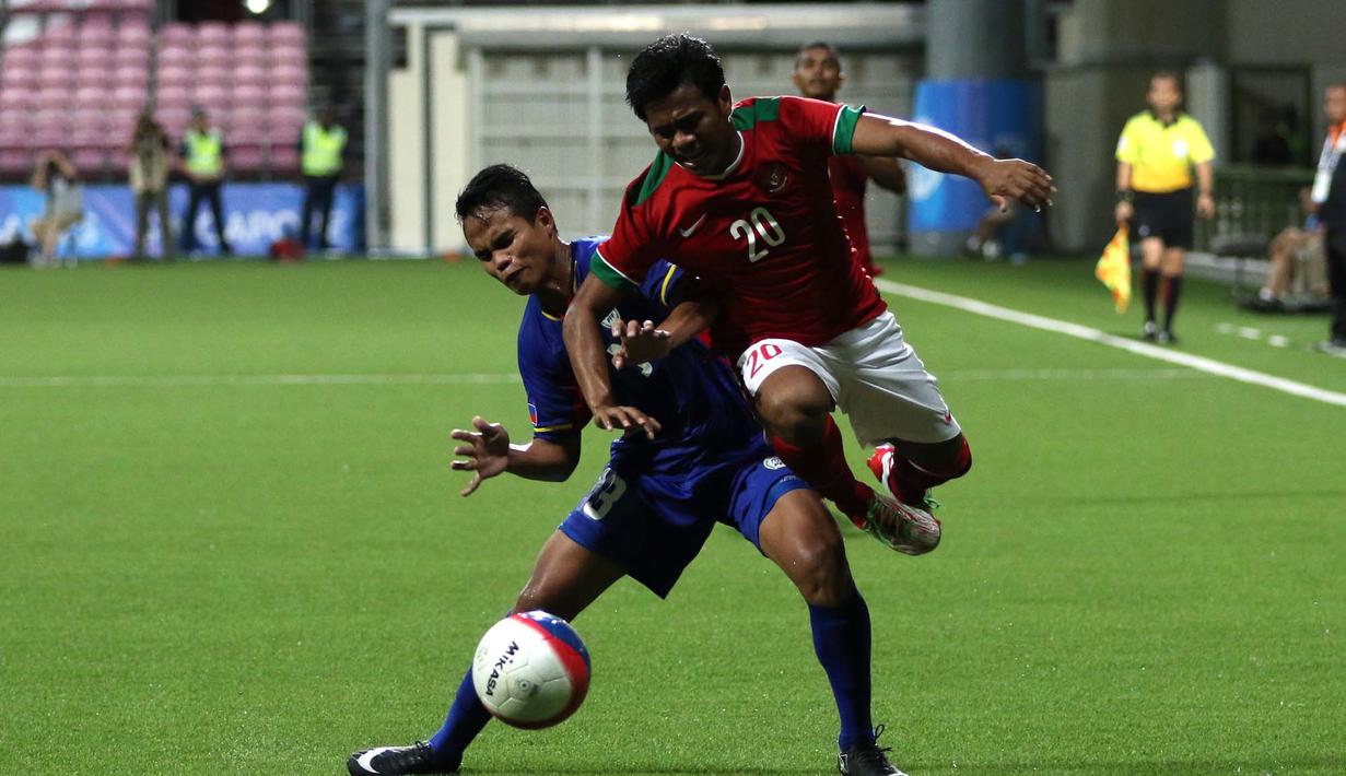 Pemain Indonesia U-23, Ilham Udin Armaiyn (kanan), berusaha melewati hadangan pemain Filipina U-23 dalam penyisihan Grup A Sepakbola SEA Games 2015 di Stadion Jalan Besar, Singapura. Selasa (9/6). (Bola.com/Arief Bagus)