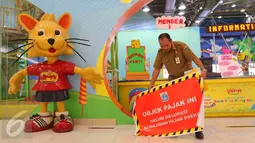 Seorang petugas saat akan memasang stiker penunggak pajak di wahana bermain anak di pusat perbelanjaan di kawasan Senayan, Jakarta, Senin (5/9). Pemasangan stiker dilakukan Dinas Pelayanan Pajak DKI lantaran menunggak pajak. (Liputan6.com/Angga Yuniar)