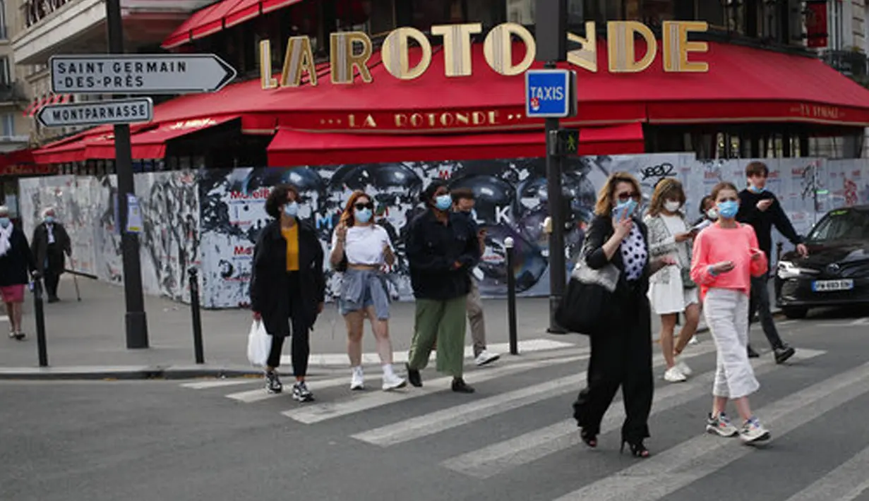 Warga berjalan pulang tepat sebelum jam malam pukul 19.00 di depan restoran Rotonde yang tutup, Paris, Prancis, Kamis (1/4/2021). Prancis bersiap melakukan lockdown setelah pemerintah menemukan adanya lonjakan kasus COVID-19. (AP Photo/Francois Mori)