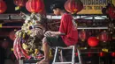 Tradisi ini sebagai bentuk penyucian tempat ibadah sekaligus simbol membersihkan diri sebelum memasuki tahun baru. Tampak dalam foto, para sukarelawan membersihkan patung-patung dewa di Kuil Hong San Ko Tee, Surabaya, Jawa Timur, pada Rabu 11 Februari 2026. (JUNI KRISWANTO/AFP)