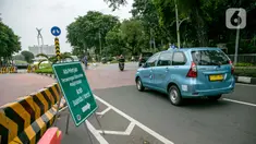 Taksi melintasi rambu lalu lintas pemberitahuan pengalihan jalan di kawasan Lapangan Banteng, Jakarta, Rabu (21/1/2021). Jalan Katedral akan ditutup selama proyek pembangunan terowongan silaturahmi Masjid Istiqlal-Gereja Katedral pada 20 Januari-31 Maret 2021. (Liputan6.com/Faizal Fanani)