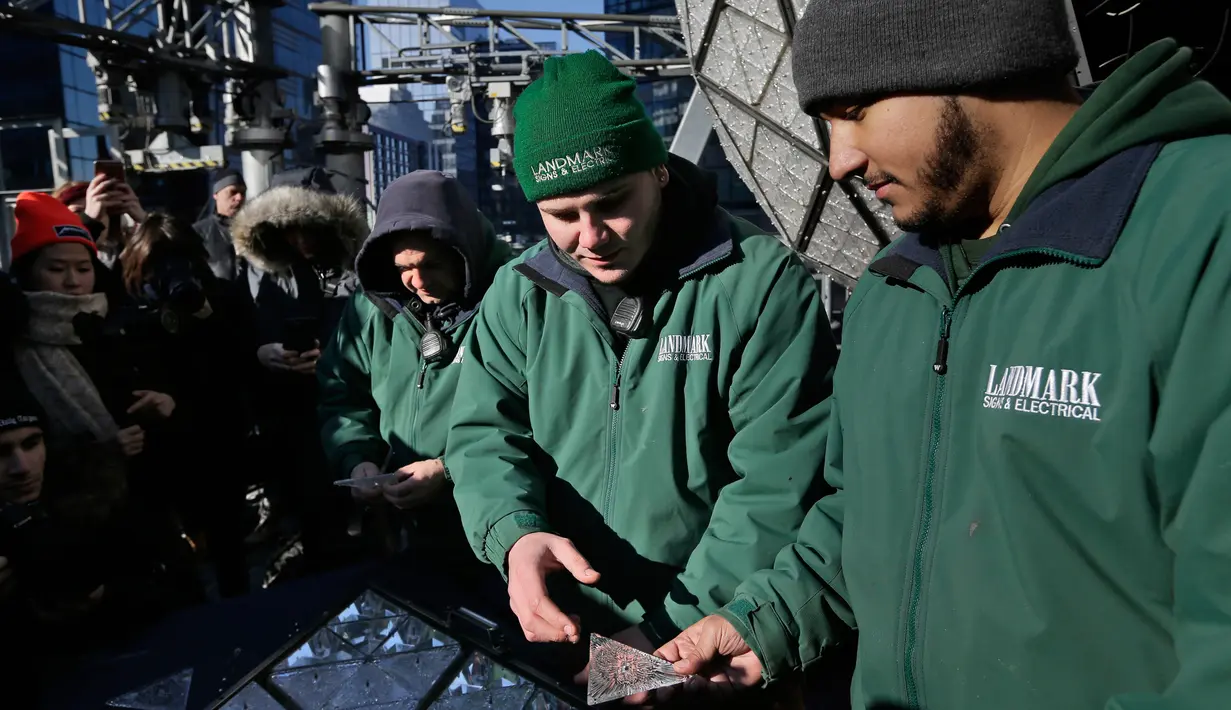 Para pekerja bersiap memasang kristal berbentuk segitiga pada bola kristal di atas One Times Square, New York, Rabu (27/12). Bola yang menjadi icon malam tahun baru di New York itu dirancang khusus oleh seniman-seniman Waterford. (AP/Seth Wenig)