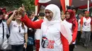 Menteri Sosial Khofifah Indar Parawansa menyapa warga saat mengikuti jalan sehat di Car Free Day, Bundaran HI, Jakarta, Minggu (6/11). Menjelang hari pahlawan Khofifah mengajak warga agar lebih mengingat jasa para pahlawan. (Liputan6.com/Gempur M. Surya)