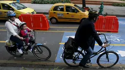Dua orang pengguna sepeda melintas di persimpangan lampu merah selama "No Car Day" di Bogota, Kolombia (4/2/2016). Selama " No Car Day" Jalur ini juga dapat dilalui para pengguna sepatu roda dan skateboard. (REUTERS/John Vizcaino)