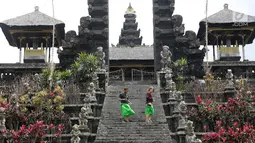 Dua orang turis mengunjungi komplek Pura Besakih, Rendang, Bali, Minggu (3/12). Jika yang biasanya ramai aktivitas dan wisatawan, Komplek Pura Besakih sepi karena masuk dalam zona Kawasan Rawan Bencana (KRB) 3 Gunung Agung.(Liputan6.com/Immanuel Antonius)