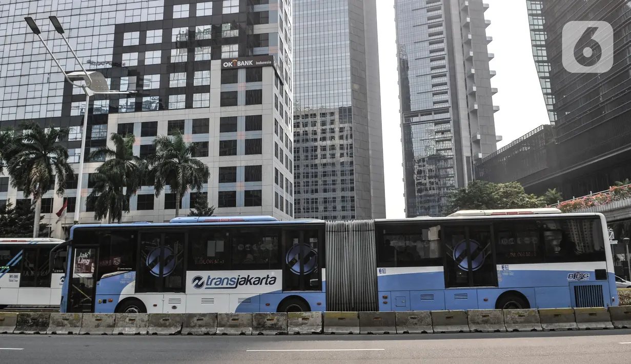 Bus gandeng Transjakarta melintas di Jalan Sudirman, Jakarta, Minggu (2/8/2020). PT Transjakarta akan menambah armada sebanyak 155 mengantisipasi lonjakan pelanggan saat diberlakukan kebijakan ganjil genap di sejumlah ruas jalan utama Jakarta pada Senin, 3 Agustus 2020. (merdeka.com/Iqbal Nugroho)