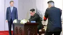 Presiden Korea Selatan, Moon Jae-in menyaksikan Pemimpin Korea Utara, Kim Jong-un menandatangani buku tamu sebelum melakukan pertemuan antar-Korea di Peace House, Jumat (2/4). Di buku tamu, Jong-un menulis kalimat perdamaian. (KOREA SUMMIT PRESS POOL/AFP)