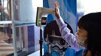 Seorang siswa menjalani pemeriksaan suhu tubuh saat tiba di Sekolah Pimarnvit, Provinsi Narathiwat, Thailand, 20 Mei 2022. Thailand melanjutkan sekolah tatap muka secara nasional untuk tahun ajaran baru setelah bertahun-tahun terganggu karena pandemi COVID-19. (Madaree TOHLALA/AFP)