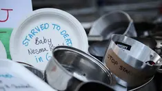 Sebuah foto yang diambil pada 25 Juli 2025 menunjukkan panci-panci masak yang bertuliskan “Mati kelaparan di Gaza” tergeletak di tanah di luar gerbang Downing Street, di pusat kota London, Inggris. (Rhianna Chadwick/AFP)