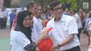 Menkumham Yasona Laoly memberikan bingkisan jelang melepas ratusan pegawai dan keluarganya untuk mudik bersama ke kampung halaman, Jakarta (22/6). Ada 5 bus yang digunakan dalam mudik bersama ini. (Liputan6.com/Helmi Afandi) 