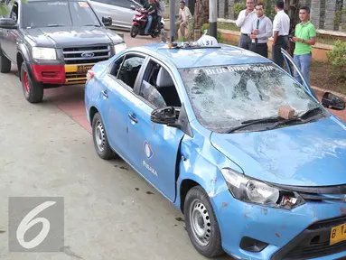 Mobil taksi yang hancur akibat dirusak oleh ojek online di Jakarta, Selasa (22/3).  Akibat aksi saling serang antara taksi dan ojek online berimbas pada kerusuhan yang terjadi di beberapa titik di Jakarta. (Liputan6.com/Angga Yuniar)