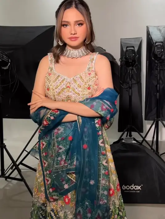 Syifa Hadju tampil dengan dress tanpa lengan dihiasi payet dan bordiran warna colorful ditambah dengan selendang biru berbordir. Ia lengkap mengenakan aksesori kalung dan anting-antingnya. [@leoafandi_]