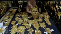 Pedagang menunjukan perhiasan emas di sebuah toko Kawasan Cikini, Jakarta, Kamis (3/9/2015). Harga emas milik PT Aneka Tambang Tbk (Antam) hari ini terpantau bergerak stabil di posisi Rp560 ribu per gram. (Liputan6.com/Johan Tallo)