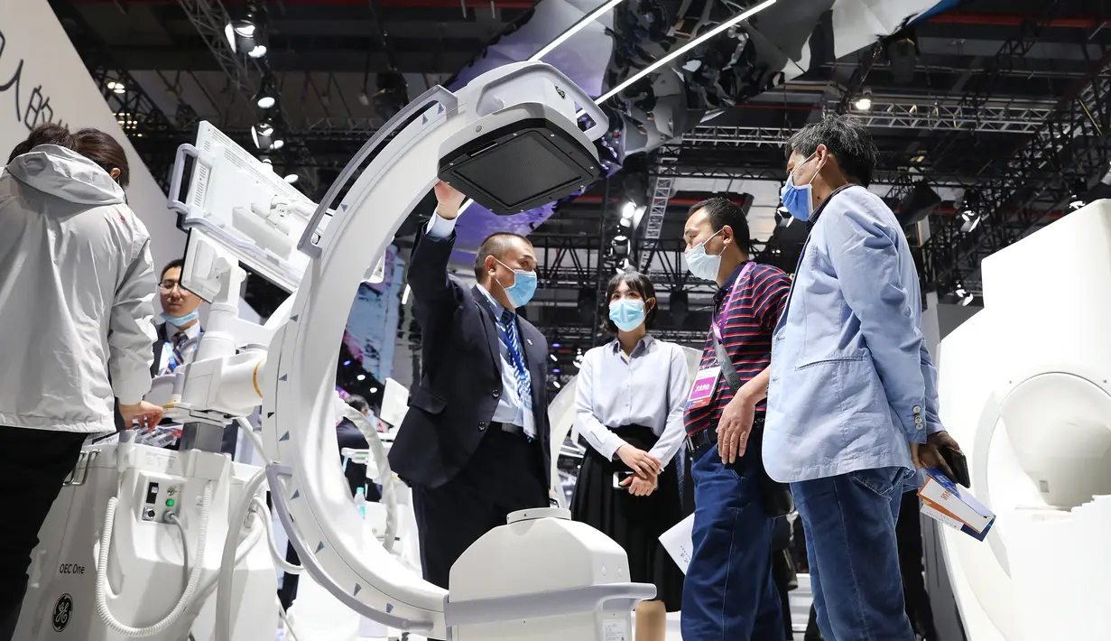 Seorang staf (keempat dari kanan) memperkenalkan sebuah mesin sinar X kepada para pengunjung dalam acara Pameran Alat Medis Internasional China (China International Medical Equipment Fair) di Shanghai, China, 19 Oktober 2020. (Xinhua/Fang Zhe)