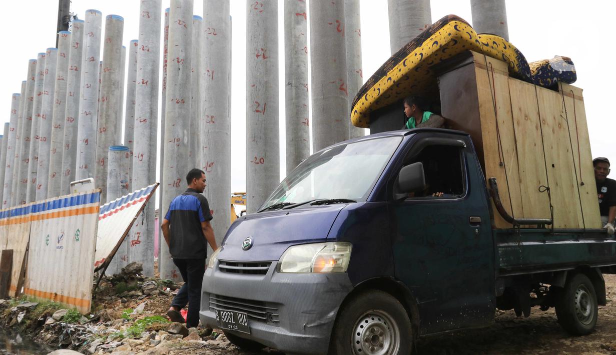 Sebuah mobil pickup mengangkut barang warga saat pembebasan lahan proyek Jalan Tol CIbitung-CIlincing seksi 4 di kawasan Semper Timur, Cilincing, Jakarta Utara, Selasa (8/11/2022). PT Cibitung Tanjung Priok Port Tollways (CTP Tollways) sebagai Badan Usaha Jalan Tol (BUJT) mencatat progres pembebasan lahan untuk seksi 4 sepanjang 7,28 km telah mencapai 100% dan ditargetkan pembangunannya selesai pada akhir tahun 2022. (Liputan6.com/Herman Zakharia)