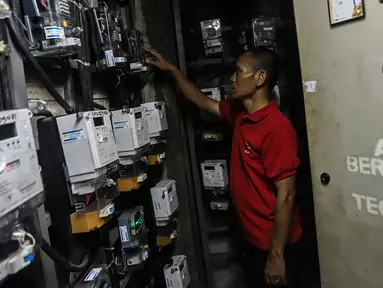 Warga memeriksa meteran listrik prabayar di Rumah Susun Benhil, Jakarta, Kamis (14/9/2022). Pemerintah akan menaikkan daya listrik bagi pelanggan yang mendapatkan subsidi, sehingga daya listrik yang semula 450 Volt Ampere (VA) akan dinaikkan menjadi 900 VA, dan yang semula daya 900 VA juga akan dinaikkan menjadi 1.200 VA. (Liputan6.com/Johan Tallo)