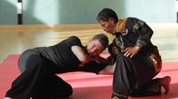 Haji Sofyan Nadar mengajarkan salah satu murid Anak Harimau teknik kuncian dalam silek Sunua. (Bola.com/Reza Khomaini)