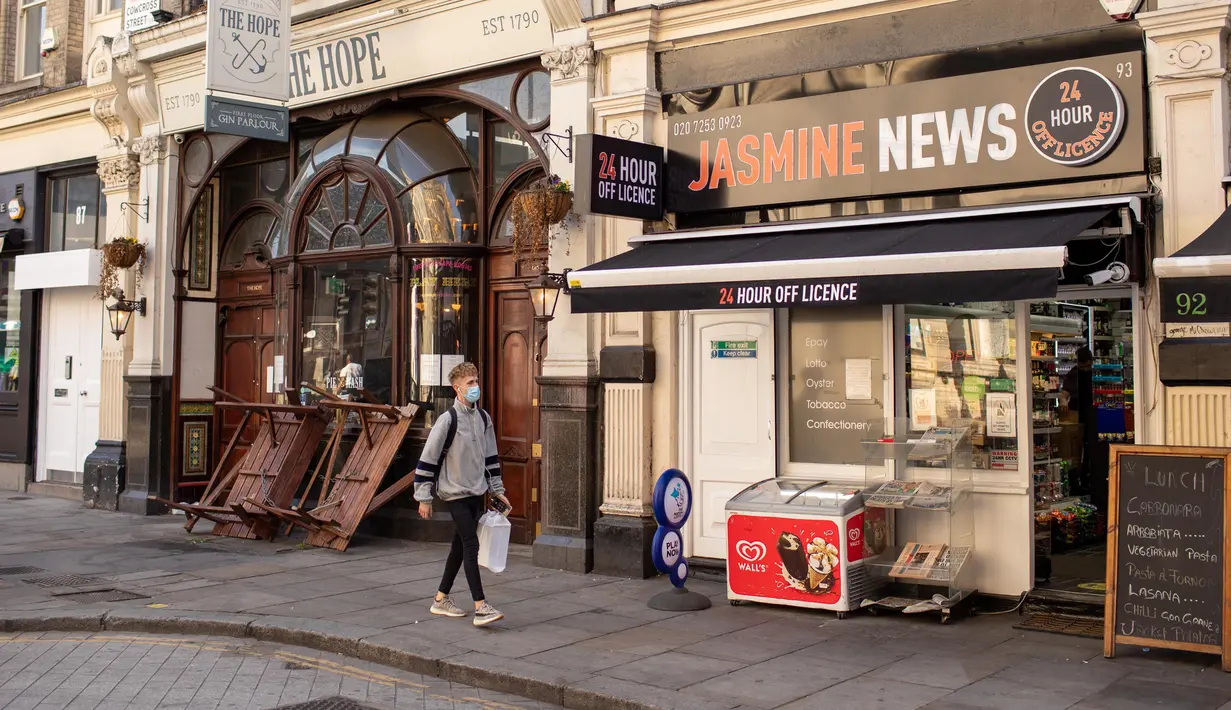 Pria yang memakai masker berjalan melewati pub yang tutup, London, Inggris, 16 September 2020. Kantor Statistik Nasional Inggris menyatakan tingkat pengangguran di Inggris naik menjadi 4,1 persen dalam tiga bulan hingga Juli, kaum muda menjadi golongan paling terdampak. (Xinhua/Tim Ireland)