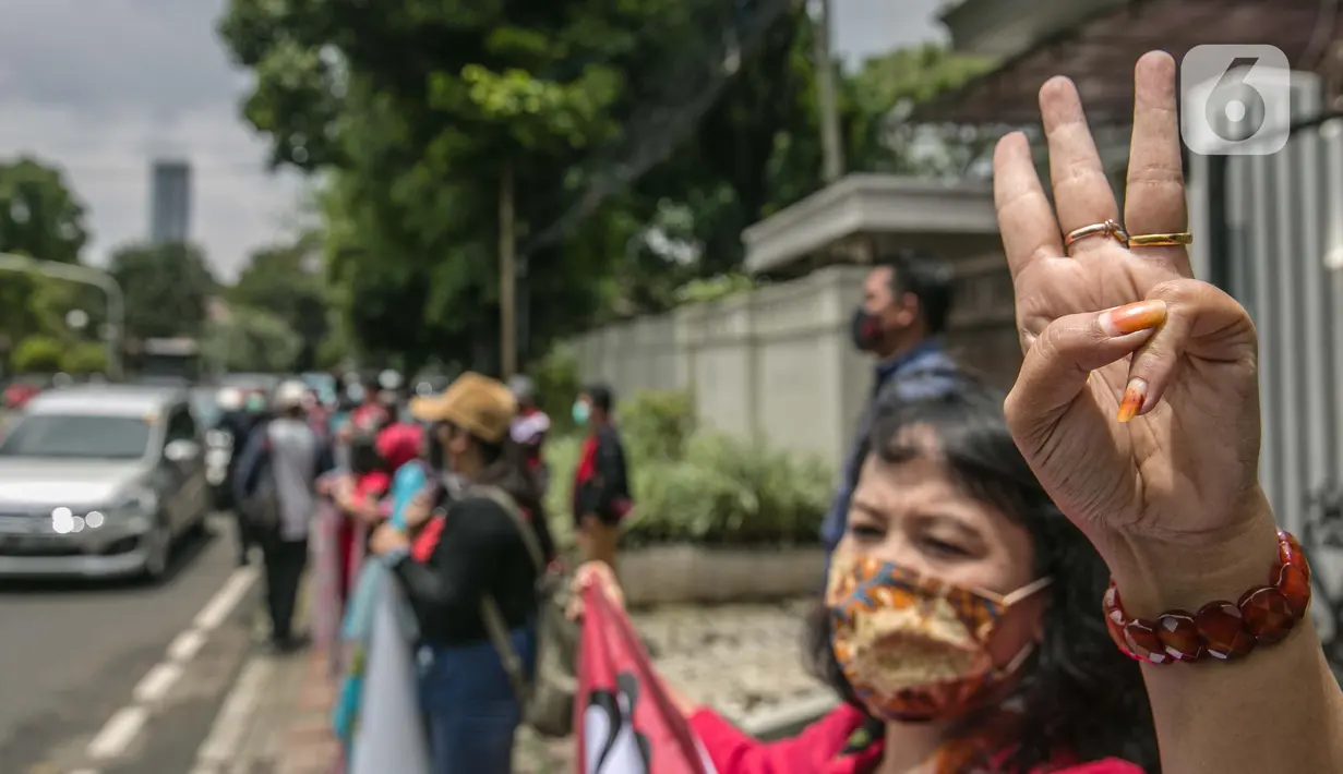 Seorang pengunjuk rasa mengangkat tiga jari saat aksi solidaritas di depan Kedubes Myanmar, Jakarta, Rabu (10/3/2021). Dalam aksi solidaritas tersebut massa mengutuk keras atas kudeta militer dan mendesak penegakan demokrasi serta perlindungan HAM di Myanmar. (Liputan6.com/Faizal Fanani)