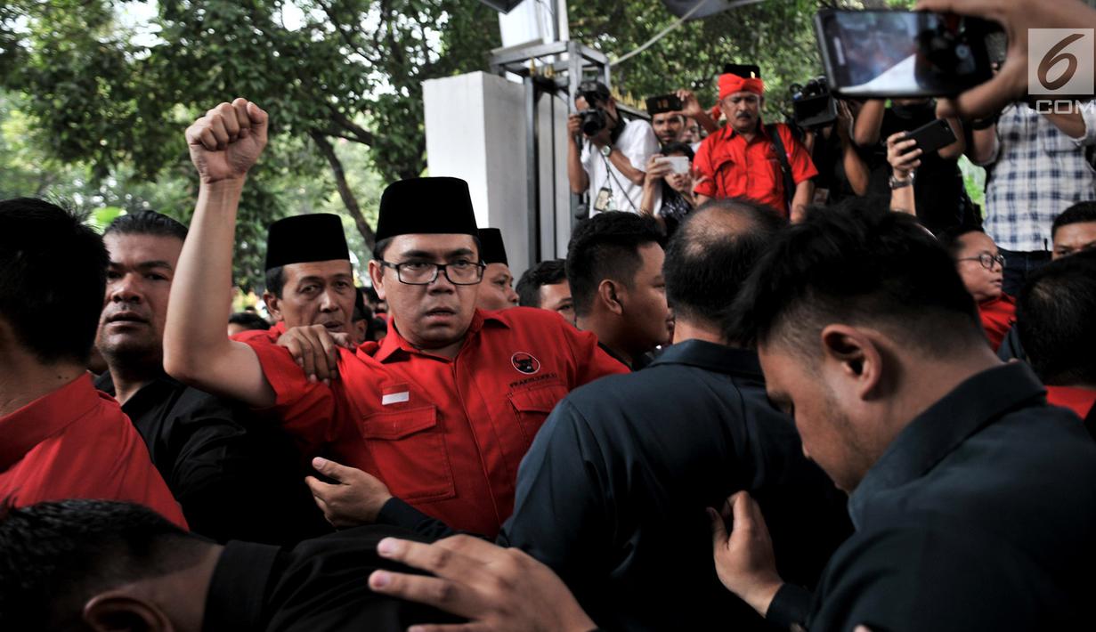Suasana saat elite dan massa PDIP  terlibat saling dorong dengan petugas keamanan saat hendak masuk untuk mengantarkan pengurus DPP mendaftarkan bakal caleg.ke Gedung KPU, Jakarta, Selasa (17/7). (Merdeka.com/ Iqbal S. Nugroho)
