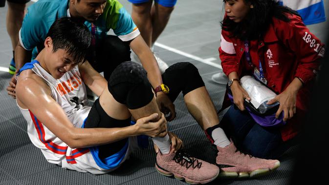 Atlet Malaysia, Yi Hou Wong mendapat perawatan tim medis usai laga antara Malaysia dan Iran di babak penyisihan Grup B basket putra 3x3 Asian Games 2018 di Jakarta, Rabu (22/8). (ANTARA FOTO/INASGOC/Ridhwan Siregar/Aa/18)