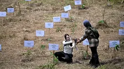 Relawan peduli lingkungan menanam pohon di Daerah Aliran Sungai (DAS) Peusangan, Negeri Antara, Bener Meriah, Aceh, Sabtu (18/7/2026). (AFP/ Chaideer Mahyuddin)