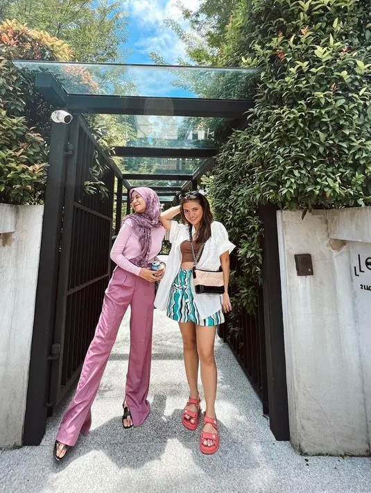 Liburan bersama bestie, Marsha tampil dengan celana pendek bermotif abstrak dengan atasan kemeja oversize putih dipadukan inner crop coklat. Semakin santai dengan sepatu sandal pink. [@aruanmarsha]