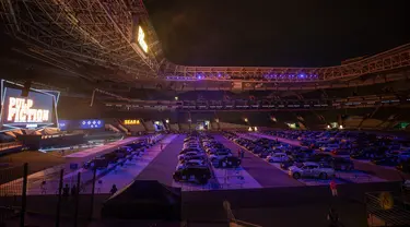 Orang-orang menonton film dari dalam mobil mereka di drive in yang dipasang di stadion sepak bola Palmeiras di Sao Paulo, Brasil, Kamis (25/6/2020). Stadion yang dapat menampung hingga 300 mobil tersebut berubah fungsi menjadi lokasi bioskop drive ini di masa pademi Covid-19. (AP Photo/Andre Penner)