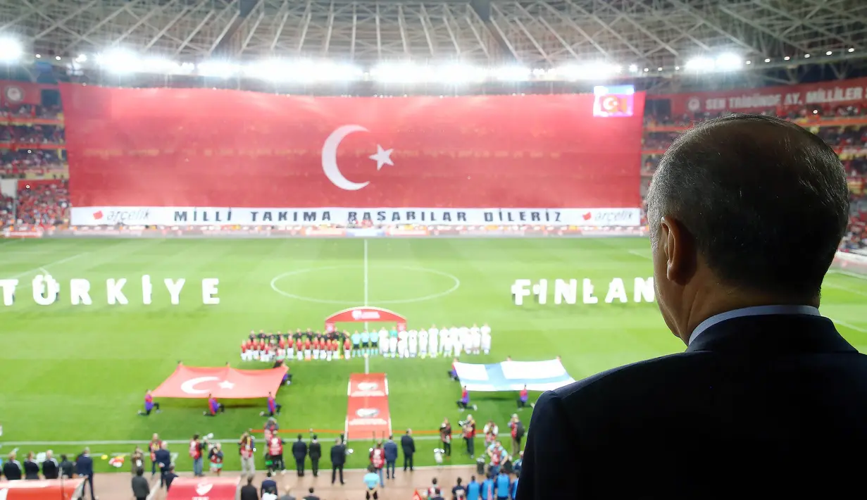 Bendera Turki di layar raksasa berkibar saat lagu kebangsaan negara asal Arda Turan itu berkumandang.  Presiden Turki, Tayyip Erdogan bersama para pemain dan penonton tampak khidmat. (AFP/Kayhan Ozer)