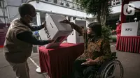Penyandang disabilitas memasukkan surat suara saat simulasi Pemilu 2024 di Kantor KPU RI, Jakarta, Selasa (22/3/2022). Simulasi digelar untuk memberikan edukasi kepada masyarakat terkait proses pemungutan dan penghitungan suara pemilu serentak tahun 2024. (Liputan6.com/Faizal Fanani)