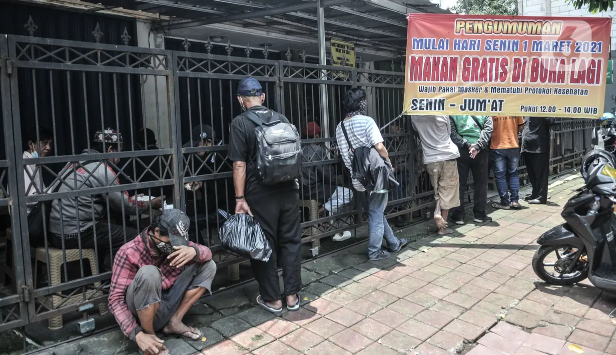 Warga menunggu giliran untuk mendapatkan layanan makan gratis di Jalan Basuki Rachmat, Cipinang Muara, Jakarta, Senin (8/3/2021). Layanan ini berlangsung setiap Senin hingga Jumat mulai pukul 12.00 sampai 14.00 WIB dengan menyediakan 70 hingga 100 porsi makanan per hari (merdeka.com/Iqbal S Nugroho)