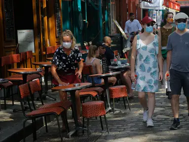 Turis berjalan-jalan di distrik Montmartre, Paris pada Senin (10/8/2020). Pemerintah Kota Paris mengumumkan masker wajib dipakai di area luar ruangan yang ramai di ibu kota Prancis itu mulai Senin (10/8) untuk mengendalikan peningkatan tingkat infeksi virus corona. (AP Photo/Michel Euler)