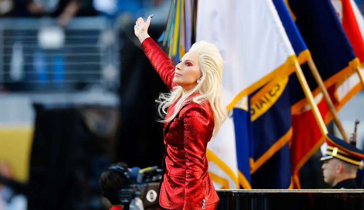 Penampilan Lady Gaga sebelum dimulainya NFL Super Bowl 50 antara Panthers Carolina dan Denver Broncos di Santa Clara, California, Minggu (7/2). Berbalut busana dari Gucci, Gaga itu tampil serba merah seperti bendera negaranya (Al Bello/Getty Images/AFP)
