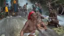 Sejumlah wanita bertelanjang dada mandi di bawah air terjun di Saut d' Eau, Haiti (15/7). Ini merupakan ritual tahunan untuk menyembuhkan penyakit dan mensucikan diri. (AFP Photo/Hektor Retamal)