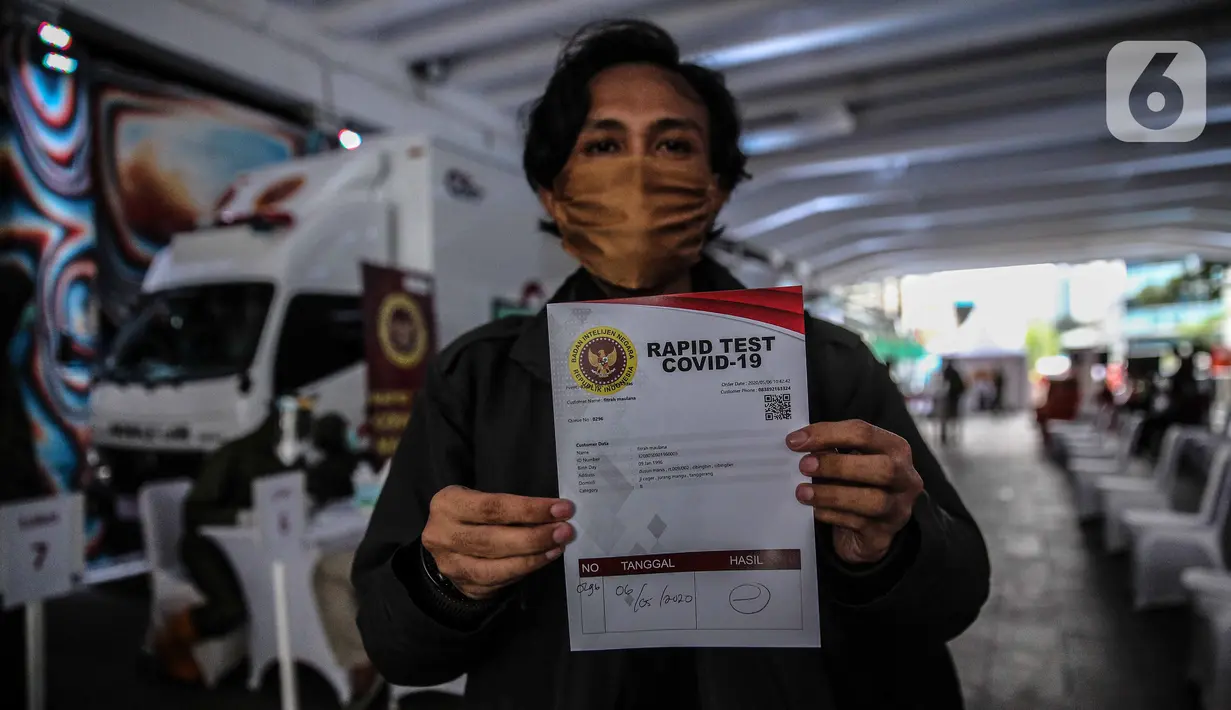 Warga menunjukkan hasil tes diagnostik cepat Covid-19 atau rapid test massal di Terowongan Kendal, Jakarta, Rabu (6/5/2020). Pemeriksaan BIN tersebut untuk mencegah penyebaran Covid-19 dari orang yang berpotensi terpapar saat beraktivitas di ruang publik. (Liputan6.com/Faizal Fanani)