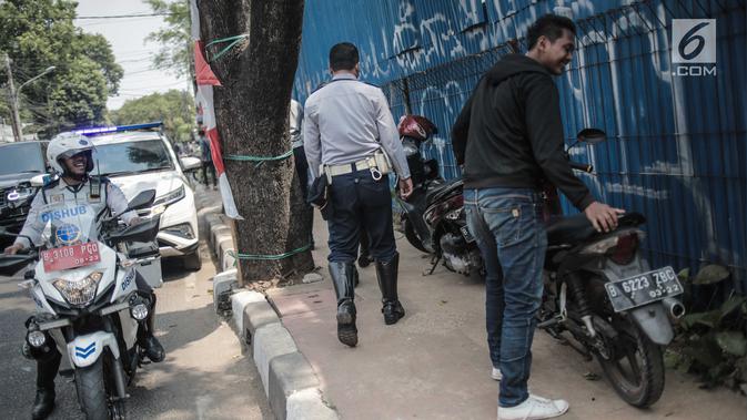 Petugas Dishub DKI Jakarta saat merazia kendaraan roda dua ang terparkir di trotoar di kawasan Cipete Raya, Jakarta, Selasa (13/8/2019). Razia tersebut dilakukan Dishub untuk mengembalikan fungsi trotoar untuk pejalan kaki. (Liputan6.com/Faizal Fanani)