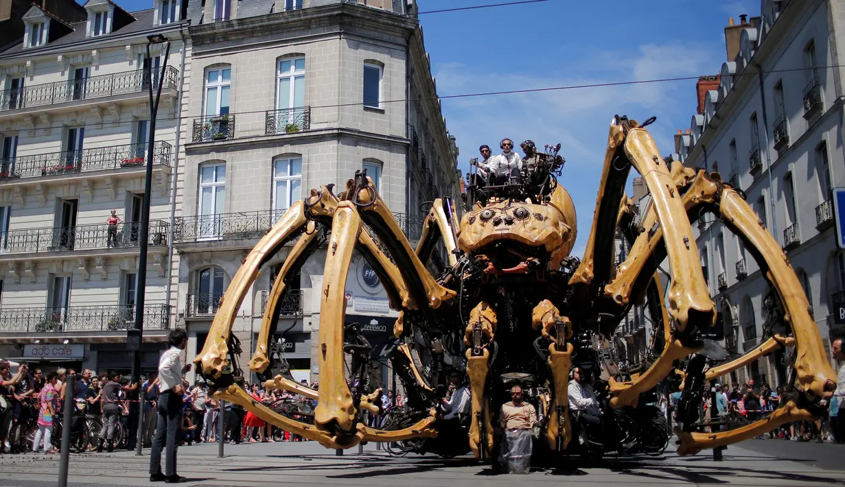Laba-laba raksasa Kumo Ni menghebohkan warga saat berjalan keliling Kota Nantes, Prancis, Jumat (8/7). Butuh lebih dari 10 orang untuk menggerakkan kaki laba-laba buatan perusahaan La Machine tersebut. (REUTERS/Stephane Mahe)