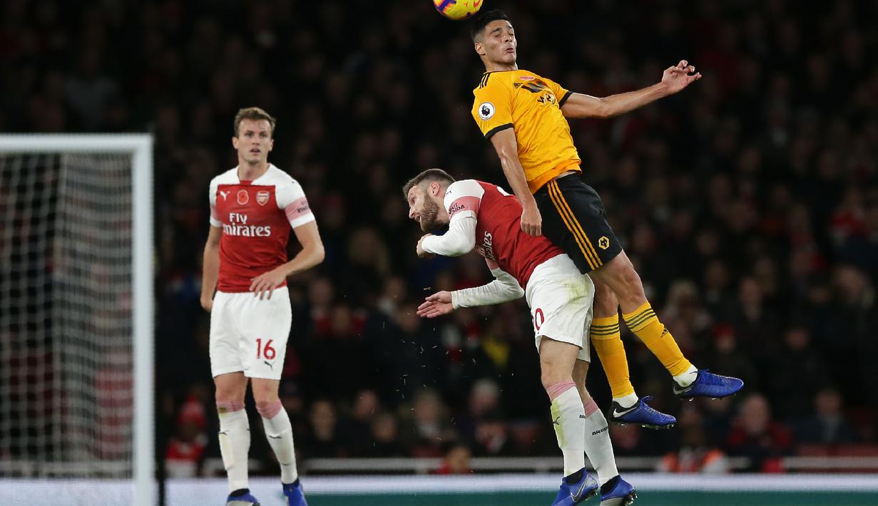 Shkordan Mustafi berduel dengan pemain Wolverhampton pada Wolverhampton pada laga lanjutan Premier League, yang berlangsung Minggu (11/11) di stadion Emirates. Arsenal ditahan imbang Wolverhampton 1-1. (AFP/Daniel Olivas)