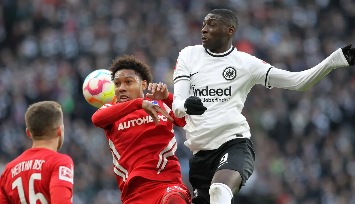 Pemain Eintracht Frankfurt, Randal Kolo Muani (kanan) berebut bola dengan pemain Hertha Berlin, Jean-Paul Boetius pada laga lanjutan Liga Jerman 2022/2023 di Deutsche Bank Park, Jerman, 4 Februari 2023. Kolo Muani sendang menjadi buah bibir karena penampilan memukaunya. Sejauh ini, pemain berkebangsaan Prancis tersebut telah membuat 11 gol dan 12 assist dalam 22 penampilan. Ia menjadi perburuan utama klub-klub besar termasuk Liverpool. (AFP/Daniel Roland)