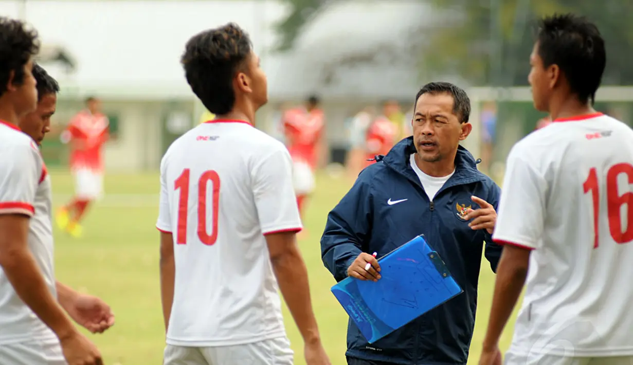 Pelatih Timnas Indonesia U23, Aji Santoso (kedua dari kanan), memberikan instruksi pada anak asuhnya saat berlaga kontra Pra PON DKI Jakarta di Karawaci, Tangerang, (9/9/2014). (Liputan6.com/Helmi Fithriansyah)