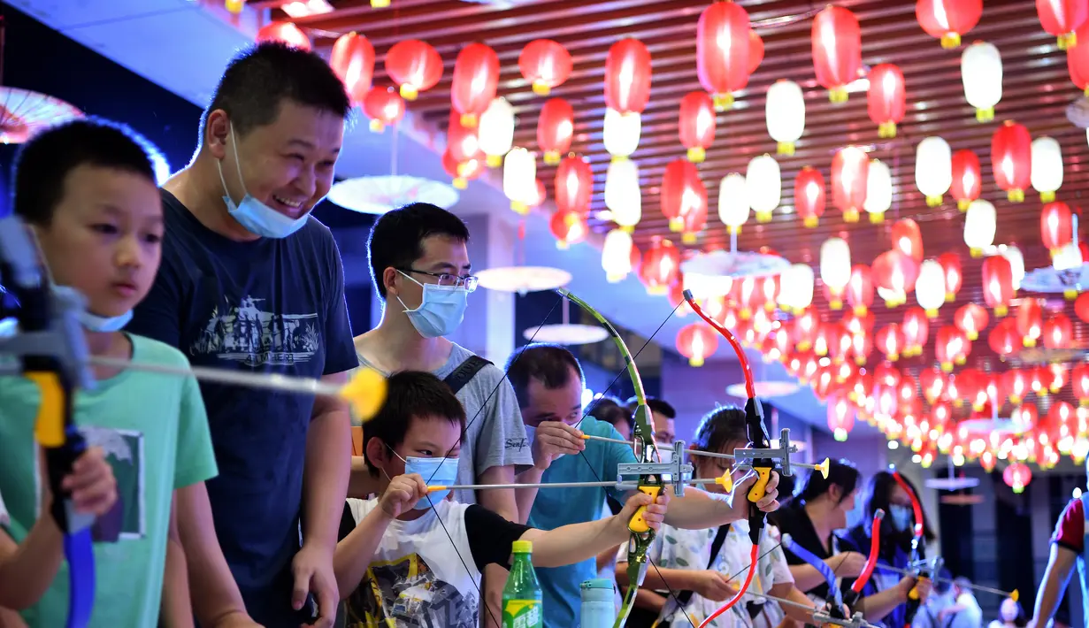 Sejumlah anak mencoba memanah dalam acara perayaan Festival Pertengahan Musim Gugur di Museum Hainan, Haikou, ibu kota Provinsi Hainan, China selatan (1/10/2020). (Xinhua/Guo Cheng)