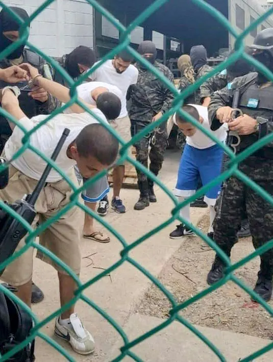 Anggota Polisi Militer untuk Ketertiban Umum (PMOP) memindahkan lebih dari 800 anggota geng Mara Salvatrucha (MS-13) ke penjara keamanan maksimum La Tolva, di kotamadya Moreceli , departemen El Paraiso, Honduras, pada 11 Juli 2023. (HANDOUT/HONDURAS MILITARIZED POLICE/AFP)