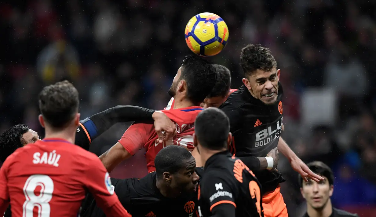 Pemain Atletico Madrid berebut bola di udara dengan pemain Valencia saat pertandingan Liga Spanyol di stadion Wanda Metropolitano, Madrid (4/2). Atas kemenangan ini Atletico Madrid kian menjauh dari Valencia dan Real Madrid. (AFP Photo/Gabriel Bouys)