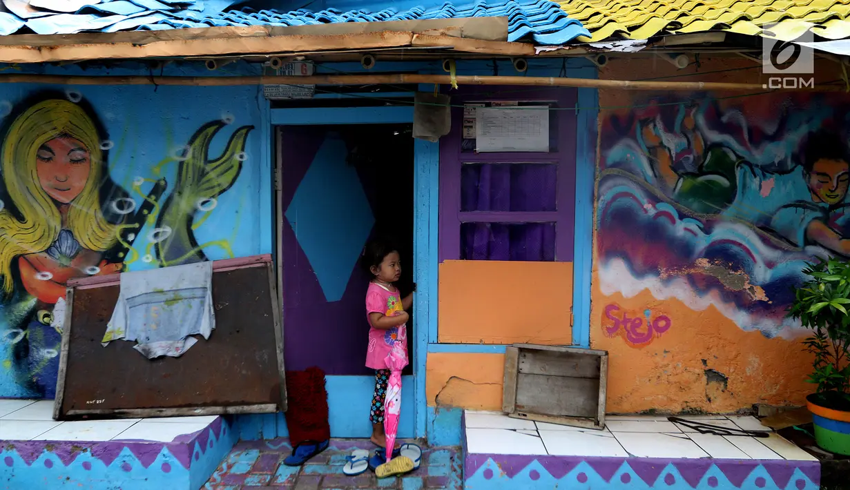 Seorang anak berdiri di depan pintu rumah dengan warna-warni cat dinding dan grafiti di Kampung Bekelir, Babakan Kota Tangerang, Jumat (16/11). Kampung ini dihuni sekitar 300 KK. (Liputan6.com/Fery Pradolo)