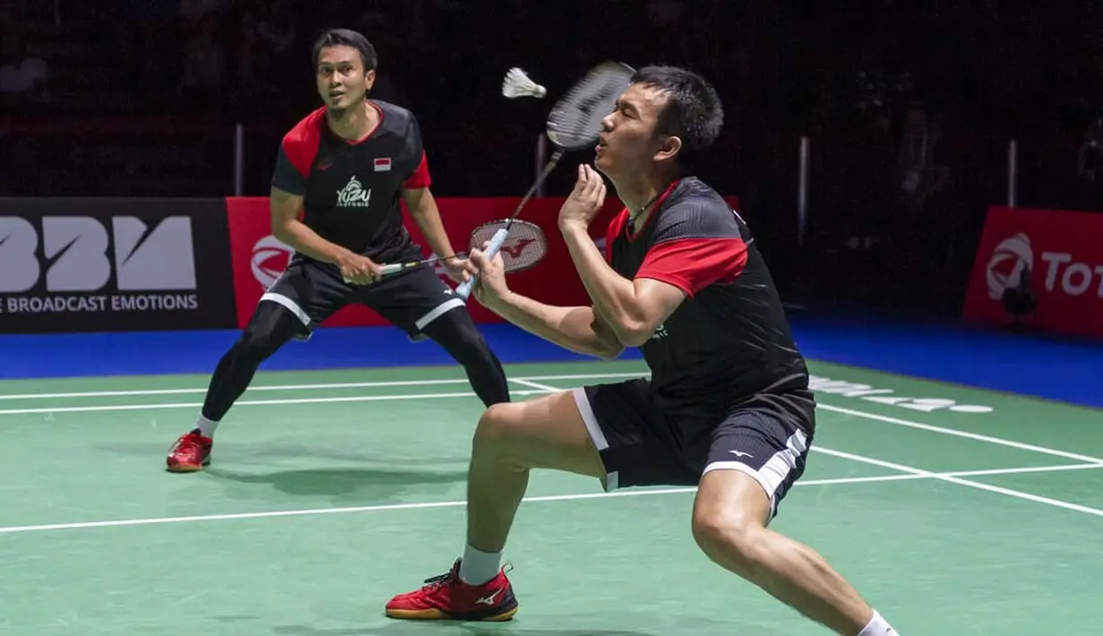 Pasangan Indonesia, Hendra Setiawan/Mohammad Ahsan saat melawan wakil Jepang, Takuro Hoki/Yugo Kobayashi, pada Kejuaraan Dunia Bulutangkis 2019 di Swiss, Minggu (25/8). Indonesia menang 25-23, 9-21, 21-15. (AP/Georgios Kefalas)